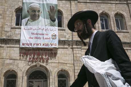 Judeu ultra-ortodoxo é visto passando em frente de um cartaz em homenagem ao Papa, na Velha Jerusalém <p>Judeu ultra-ortodoxo é visto passando em frente de um cartaz em homenagem ao Papa, na Velha Jerusalém</p>