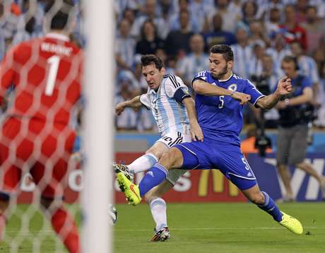 Messi e Kolasinac brigam pela bola em frente ao gol de Asmir Begovic Messi e Kolasinac brigam pela bola em frente ao gol de Asmir Begovic