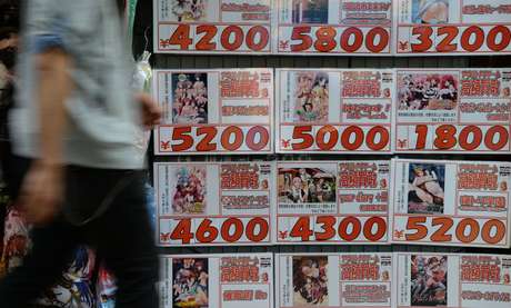 Um homem caminha próximo a uma loja de de DVDs de segunda mão que exibe propaganda de vídeos pornográficos, em Tóquio, Japão, em 4 de junho <p>Um homem caminha próximo a uma loja de de DVDs de segunda mão que exibe propaganda de vídeos pornográficos, em Tóquio, Japão, em 4 de junho</p>