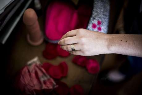 Ela carrega uma bolsinha com pétalas artificiais de rosas, preservativos, algemas, máscara e um pênis de borracha <p>Ela carrega uma bolsinha com pétalas artificiais de rosas, preservativos, algemas, máscara e um pênis de borracha</p>