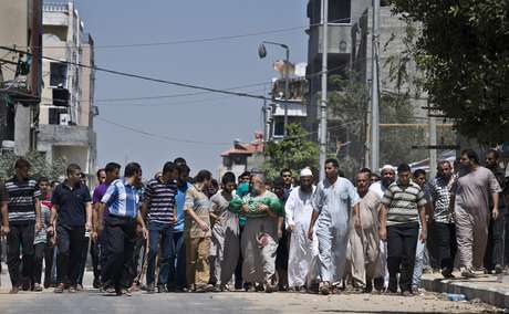 Palestino Abu Bilal (ao centro) carrega sua neta de 1 ano e meio, ao lado de diversos amigos e familiares, durante seu cortejo fúnebre para o cemitério local, na Cidade de Gaza, neste domingo, 24 de agosto. De acordo com testemunhas, ela foi morta quando um míssil atingiu seu bairro <p>Palestino Abu Bilal (ao centro) carrega sua neta de 1 ano e meio, ao lado de diversos amigos e familiares, durante seu cortejo fúnebre para o cemitério local, na Cidade de Gaza, neste domingo, 24 de agosto. De acordo com testemunhas, ela foi morta quando um míssil atingiu seu bairro</p>