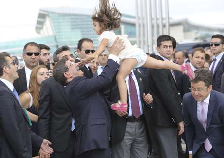 O primeiro-ministro turco, Ahmet Davutoglu (ao centro), joga para o alto a filha do Cônsul Geral da Turquia em Mossul, Ozturk Yilmaz, ao comemorar a chegada dos reféns do Estado Islâmico <p>O primeiro-ministro turco, Ahmet Davutoglu (ao centro), joga para o alto a filha do Cônsul Geral da Turquia em Mossul, Ozturk Yilmaz, ao comemorar a chegada dos reféns do Estado Islâmico </p><p> </p>