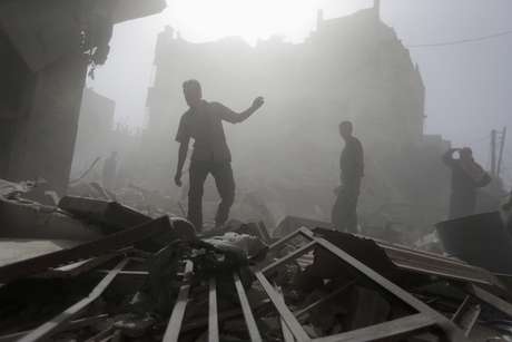Moradores das áreas atingidas pelos bombardeios da coalização, liderada pelos EUA, andam entre escombros <p>Moradores das áreas atingidas pelos bombardeios da coalização, liderada pelos EUA, andam entre escombros</p>