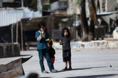 Crianças sírias comem milho em uma rua em Douma, no leste da al-Ghouta, perto de Damasco; o EI fechou escolas ao leste do país nesta sexta Crianças sírias comem milho em uma rua em Douma, no leste da al-Ghouta, perto de Damasco; o EI fechou escolas ao leste do país nesta sexta