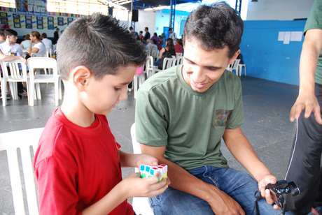 O professor Caio Ferraro observa aluno treinando a montagem do cubo O professor Caio Ferraro observa aluno treinando a montagem do cubo
