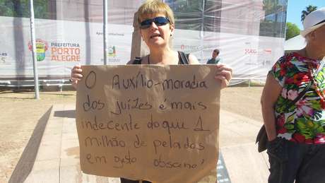 Eliane Lima carrega cartaz que relaciona obscenidade com benefícios do judiciário Eliane Lima carrega cartaz que relaciona obscenidade com benefícios do judiciário