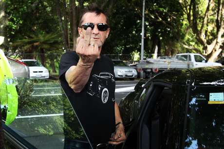 Phil Rudd mostra o dedo para fotógrafo em saída de tribunal Phil Rudd mostra o dedo para fotógrafo em saída de tribunal