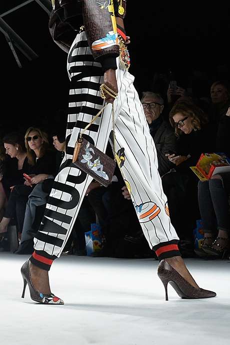 O logotipo da calça esportiva da Moschino se mistura a outros desenhos infantis no look, inclusive o coelho Pernalonga estampado na bolsa <p class="text">O logotipo da calça esportiva da Moschino se mistura a outros desenhos infantis no look, inclusive o coelho Pernalonga estampado na bolsa</p><p class="text"> </p>