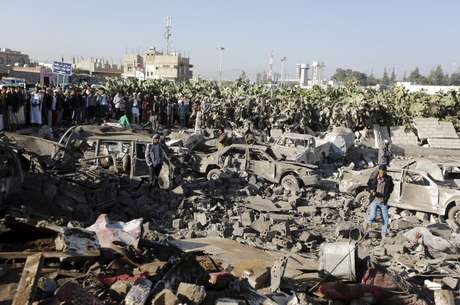 Pessoas cercam área alvo de um ataque aéreo nos arredores do aeroporto de Sanaa Pessoas cercam área alvo de um ataque aéreo nos arredores do aeroporto de Sanaa