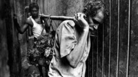 A remoção é um trabalho árduo e as ferramentas para isso são primitivas: as mãos são usadas para levantar o lixo e os ombros, para carregá-lo. Jadhav, que atua nessa função há vários anos, não gosta de falar sobre seu trabalho. Há cicatrizes em seus ombros, provocadas pelas varas de madeira. Questionado sobre dores, ele acena com a cabeça A remoção é um trabalho árduo e as ferramentas para isso são primitivas: as mãos são usadas para levantar o lixo e os ombros, para carregá-lo. Jadhav, que atua nessa função há vários anos, não gosta de falar sobre seu trabalho. Há cicatrizes em seus ombros, provocadas pelas varas de madeira. Questionado sobre dores, ele acena com a cabeça