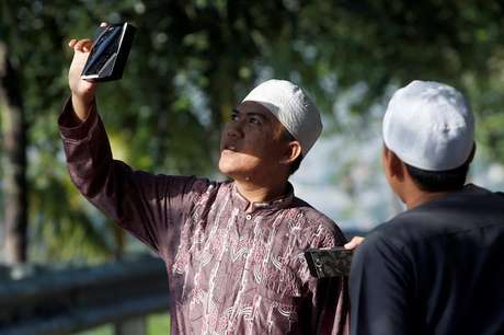 Un hombre utiliza un filtro de película para ver el eclipse