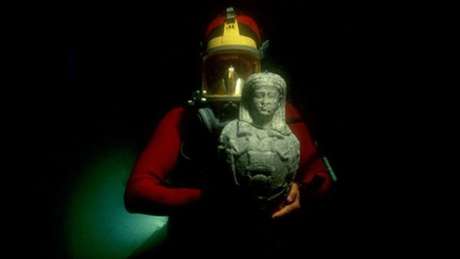Os objetos encontrados no fundo do mar revelam histórias sobre a política e a cultura dessas civilizações e permitem saber mais sobre os seus deuses e reis. Nesta imagem, um mergulhador mostra uma estátua de mármore do deus Osíris encontrada em Canopus. Elas datam dos século 1 e 2.