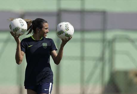 La futbolista Marta, de Brasil, sostiene dos balones durante un entrenamiento para la semifinal de los Juegos Olímpicos, el lunes 15 de agosto de 2016, en Río de Janeiro
