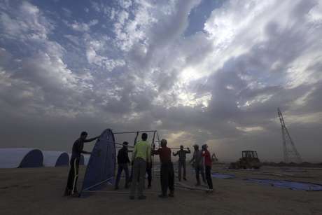 Trabajadores levantan un campamento para iraquíes desplazados en Khazer, Irak, el miércoles 19 de octubre de 2016.