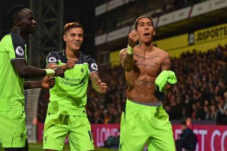 Coutinho e Firmino comemoram gol do brasileiro, que tirou a camisa após o seu gol (Foto: Glyn Kirk / AFP) Coutinho e Firmino comemoram gol do brasileiro, que tirou a camisa após o seu gol (Foto: Glyn Kirk / AFP)
