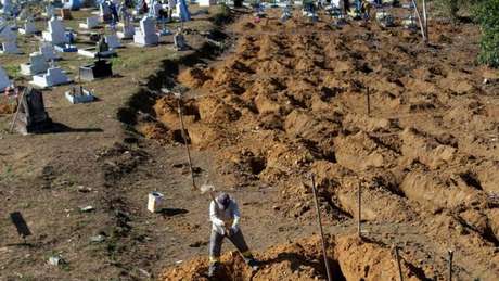 Homem abre covas para enterro de presos mortos durante rebelião em Manaus 
