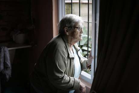AP Foto/Victor R. Caivano / AP en español En esta imagen tomada el 13 de febrero de 2017, María Antonieta Lobos, que perdió un hijo en la guerra de las Malvinas, mira por la ventana de su casa en Buenos Aires, Argentina. Lobos dice que nunca ha podido hacer el duelo por José Antonio, quien murió el 14 de junio de 1982, el último día de la guerra entre Argentina y Gran Bretaña por el archipiélago, porque no sabe dónde están sus restos.