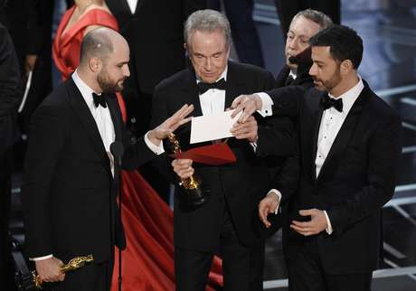 El productor de "La La Land" Jordan Horowitz, a la izquierda, el presentador Warren Beatty, en el centro, y el presentador Jimmy Kimmel, a la derecha, miran un sobre que anunciaba a "Moonlight" como ganadora del premio a mejor película, el domingo 26 de febrero de 2017, en el teatro Dolby de Los Ángeles.