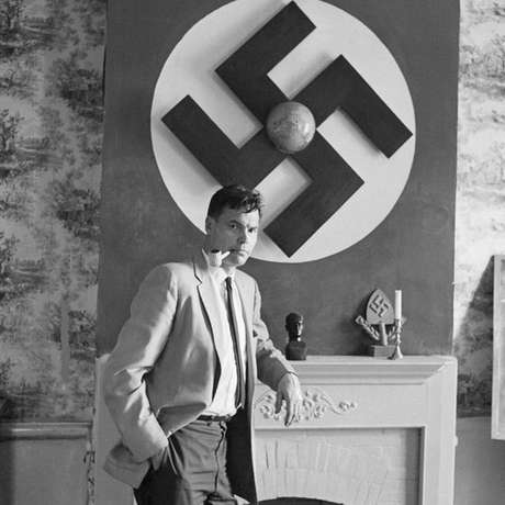 Rockwell com uma bandeira nazista ao fundo Rockwell com uma bandeira nazista ao fundo