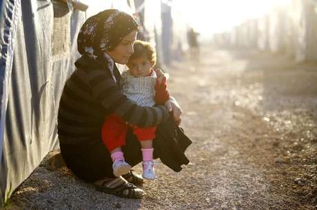 Refugiada curda segura criança em campo de refugiados na cidade de Suruç, na Turquia 