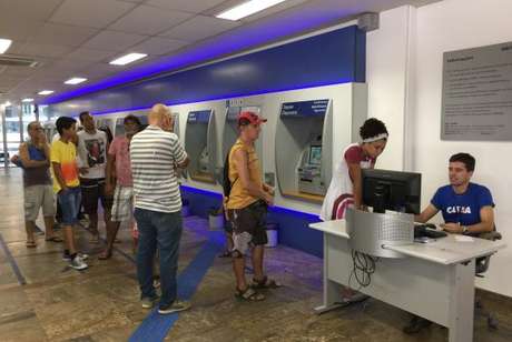 Muita gente uso ou caixa eletrônico para sacar o dinheiro das contas inativas do FGTS Muita gente uso ou caixa eletrônico para sacar o dinheiro das contas inativas do FGTS