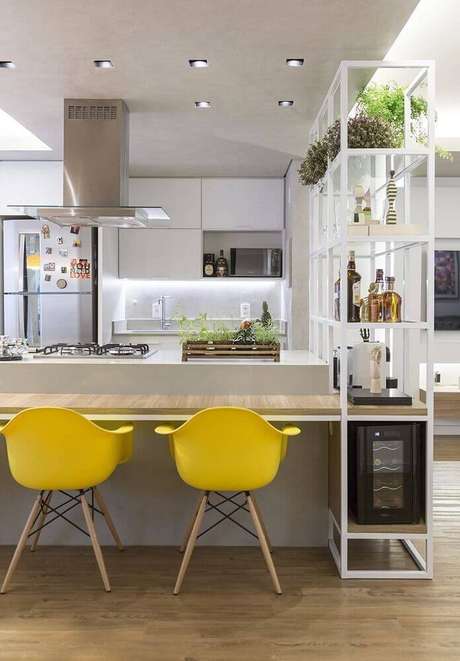 19. Cozinha com coifa de vidro sobre a ilha trazendo um toque leve ao ambiente 19. Cozinha com coifa de vidro sobre a ilha trazendo um toque leve ao ambiente