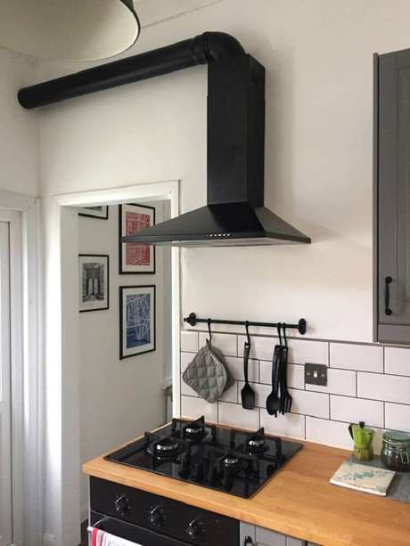 12. Decoração no estilo minimalista em cozinha com coifa de parede preta. 12. Decoração no estilo minimalista em cozinha com coifa de parede preta.