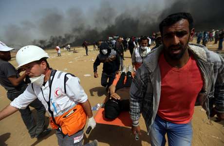 Resultado de imagem para Manifestante ferido é carregado durante confronto com soldados israelenses na fronteira entre Israel e Gaza