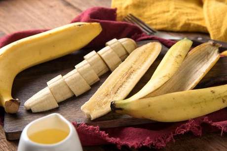 Banana fatiada ao lado da casca da fruta
