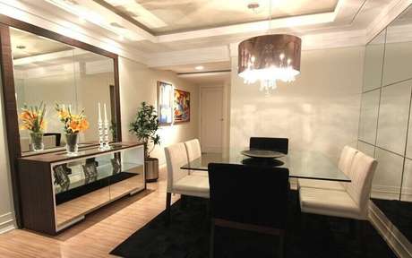 26 – Aqui, o buffet para sala de jantar com espelho grande ajudou a deixar a decoração bem sofisticada e iluminada 26 – Aqui, o buffet para sala de jantar com espelho grande ajudou a deixar a decoração bem sofisticada e iluminada