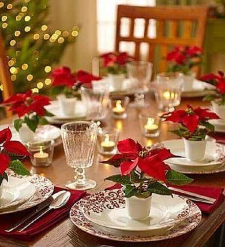 12- Sobre os pratos da mesa da ceia foram utilizados pequenos vasos com flor de natal artificial. Fonte: Pinterest 12- Sobre os pratos da mesa da ceia foram utilizados pequenos vasos com flor de natal artificial. Fonte: Pinterest