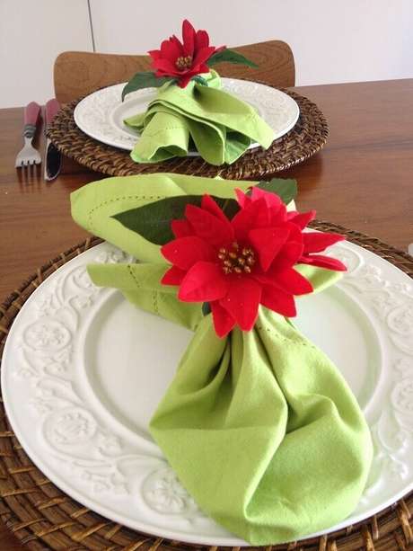 38- Os guardanapos verdes tem arranjo com flor de natal. Fonte: Pinterest 38- Os guardanapos verdes tem arranjo com flor de natal. Fonte: Pinterest