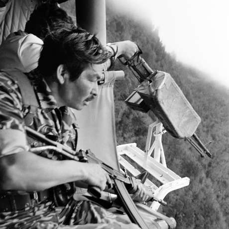 Soldado da Guatemala preparando para atacar indígenas maias de um helicóptero americano, em Santa Cruz Quiché, em 1982