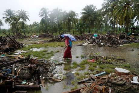 Mulher anda entre os escombros deixados pelo tsunami na IndonÃ©sia