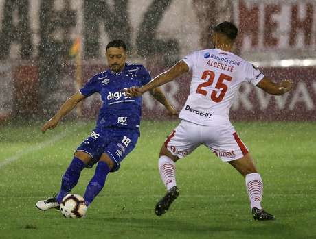 Robinho e Alderete disputam a bola em meio Ã  chuva