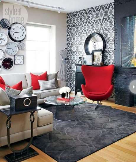 42. Decoração para sala em tons de vermelho e cinza com papel de parede e vários relógios – Foto: StyleAtHome 42. Decoração para sala em tons de vermelho e cinza com papel de parede e vários relógios – Foto: StyleAtHome