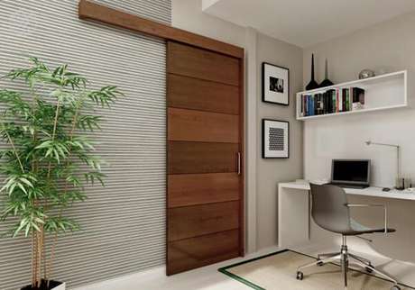 110 – Os modelos de portas de correr com trilhos na parte superior economizam espaço no pequeno home office. Fonte: Pinterest