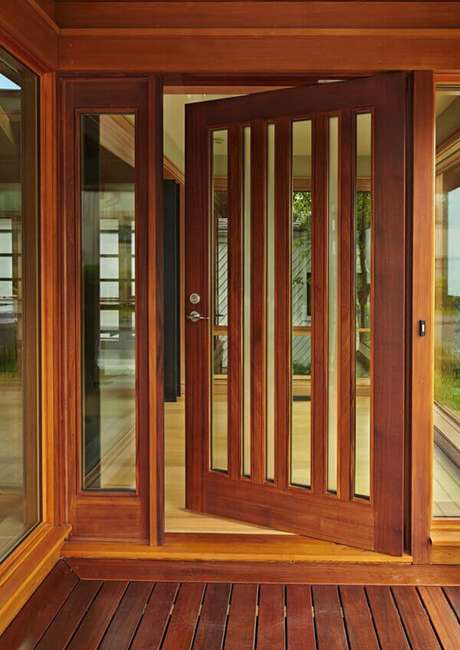 22- Os modelos de portas de abrir com braçadeiras em madeira natural e detalhes em vidro são ideais para hall de entrada. Fonte: 321achei