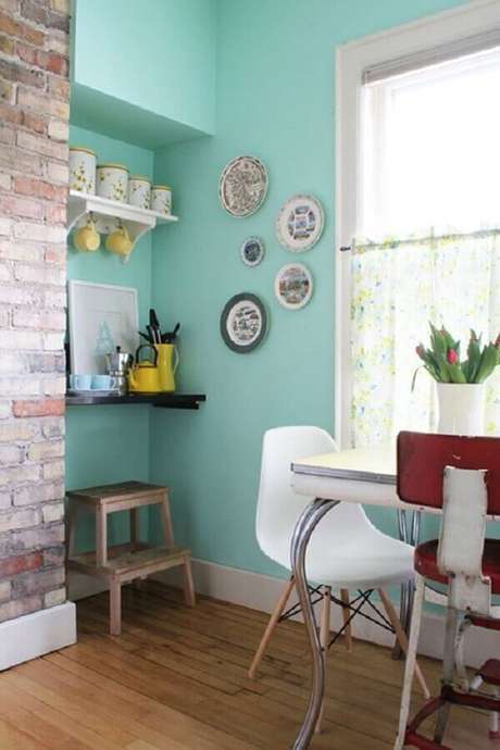 29. A decoração da sala de jantar ficou muito mais interessante com a parede de tijolinho e a parede com tinta verde água – Foto: House of Jade Interiors