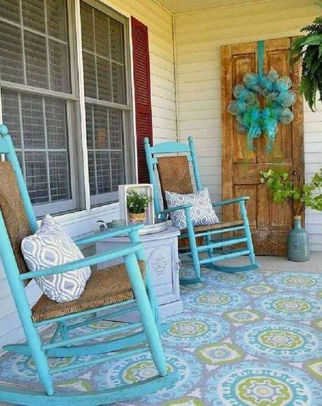 6. Decoração simples com cadeira de balanço para varanda pintada de azul e com piso estampado – Foto: QuitDecor 6. Decoração simples com cadeira de balanço para varanda pintada de azul e com piso estampado – Foto: QuitDecor