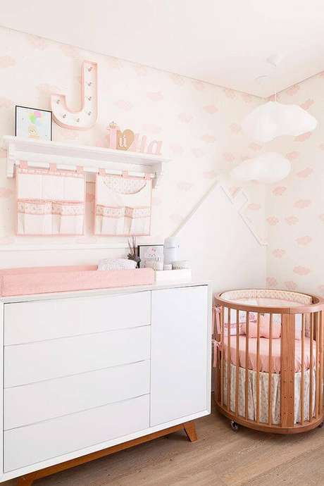 56. Delicada decoração com prateleira para quarto de bebê menina com lustre de nuvem e mini berço – Foto: Ideas de Casa