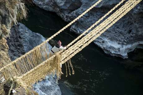 Um homem amarra as cordas para criar um corrimão