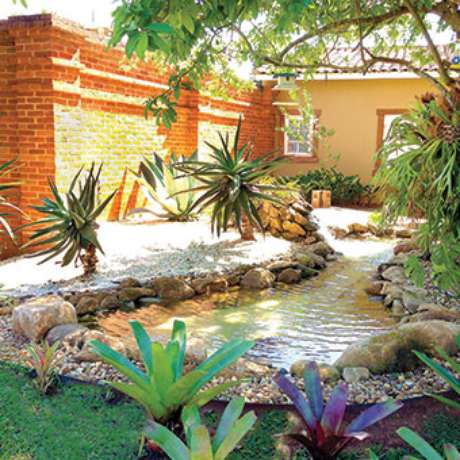 35. Um lindo lago ornamental rodeado por plantas no jardim – Por: Pinterest