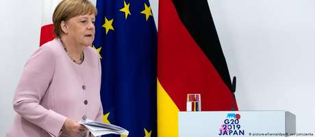Merkel, durante a reunião do G20, no Japão. Tremores provocaram especulações sobre seu estado de saúde Merkel, durante a reunião do G20, no Japão. Tremores provocaram especulações sobre seu estado de saúde