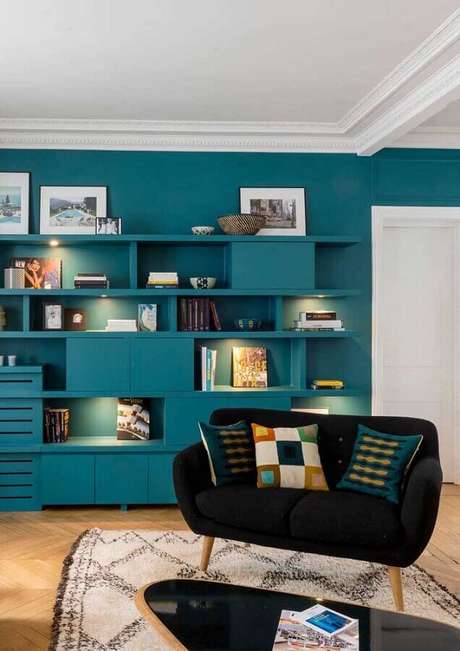26. Sala decorada com sofá namoradeira com design retrô e estante azul – Foto: We Heart It