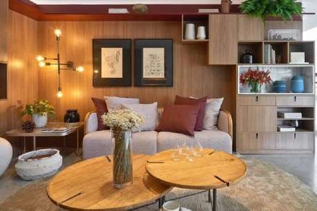 47. Sala sofisticada decorada com revestimento de madeira e sofá namoradeira – Foto: Rocha e Rodrigues