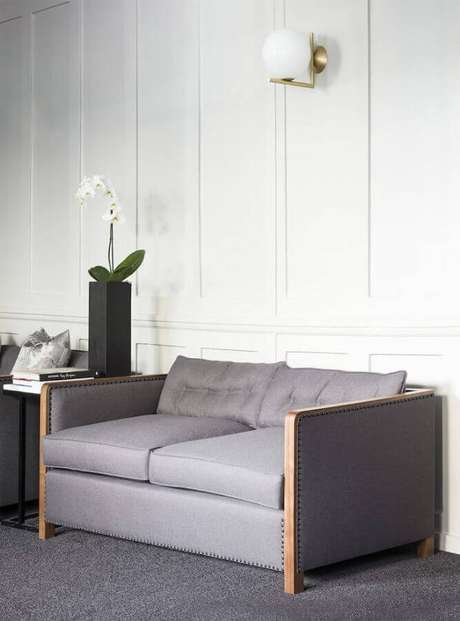54. Modelo simples de sofá namoradeira cinza com detalhe em madeira – Foto: Casa Botelho