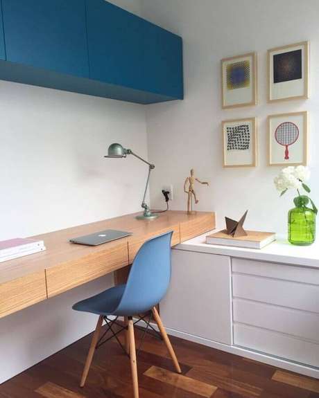 23. O home office recebeu detalhes em azul petróleo cor na decoração e uma bancada de madeira para trazer sensação de ambiente aconchegante – Foto: Tripper Arquitetura