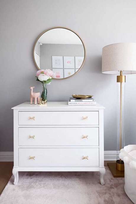37. Decoração clean com cômoda branca com puxador em formato de laço e espelho redondo – Foto: Decorpad 37. Decoração clean com cômoda branca com puxador em formato de laço e espelho redondo – Foto: Decorpad