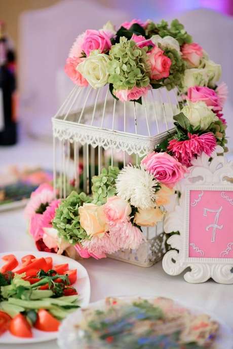 51. Gaiolas decorativas com flores naturais enfeitam o centro de mesa. Fonte: Pinterest 51. Gaiolas decorativas com flores naturais enfeitam o centro de mesa. Fonte: Pinterest